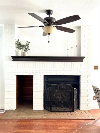 a living room with a fireplace and a ceiling fan