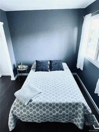 a bedroom with a bed and hardwood floor