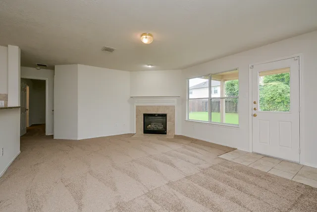 an empty room with windows and fireplace
