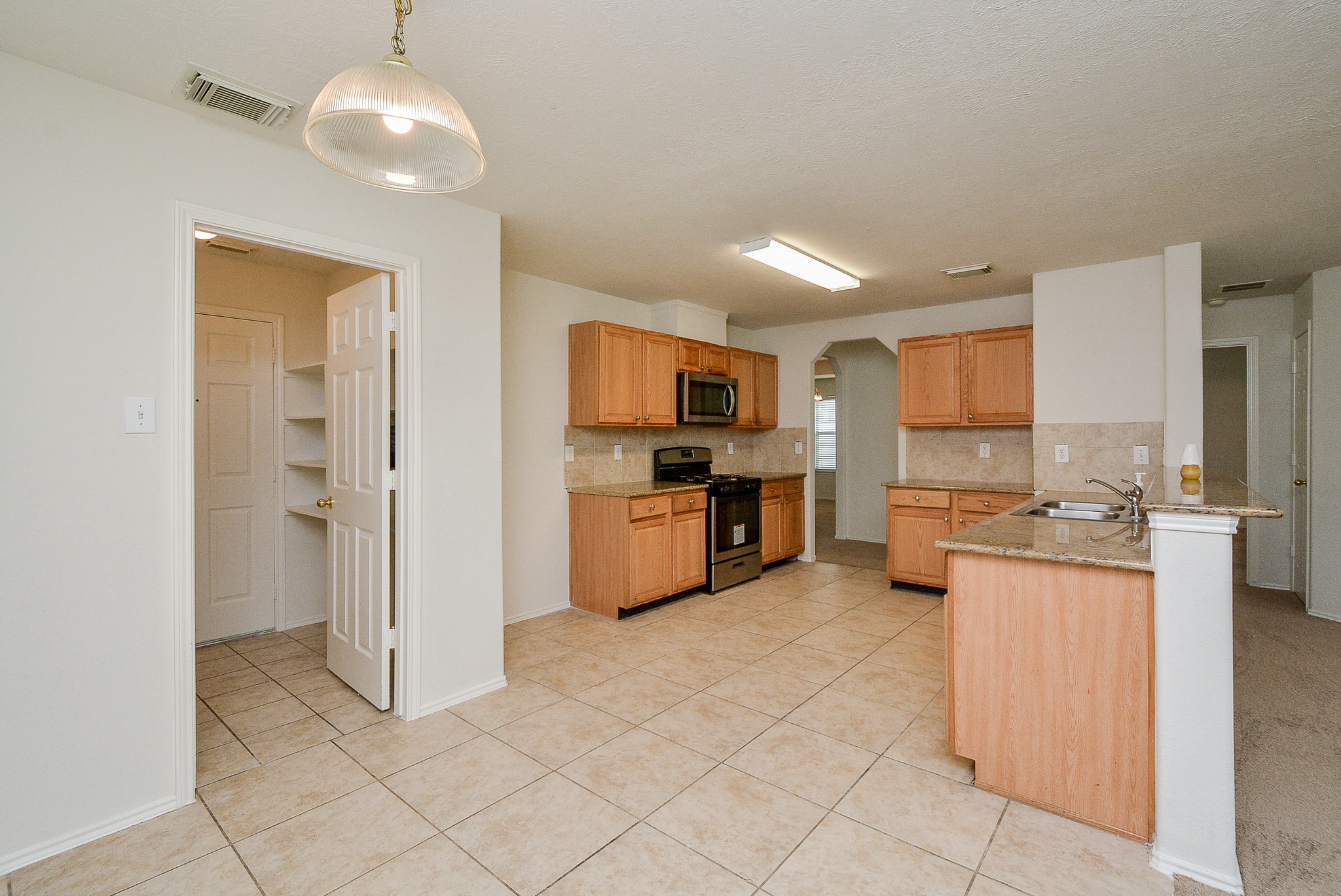 18326 Thicket Grove Road Houston, TX 77084 - Photo 16 of 50 a large kitchen with cabinets and stainless steel appliances
