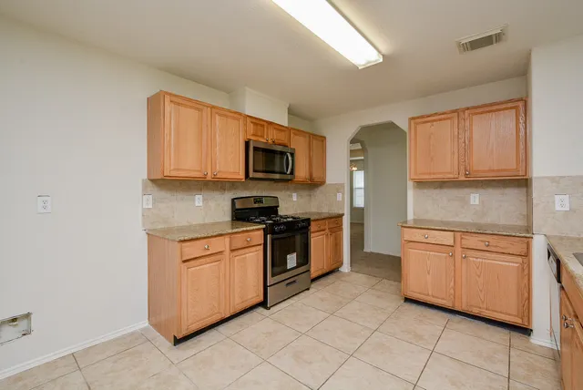 a kitchen with stainless steel appliances granite countertop a stove top oven a sink dishwasher and a microwave oven on the blue kitchen countertops