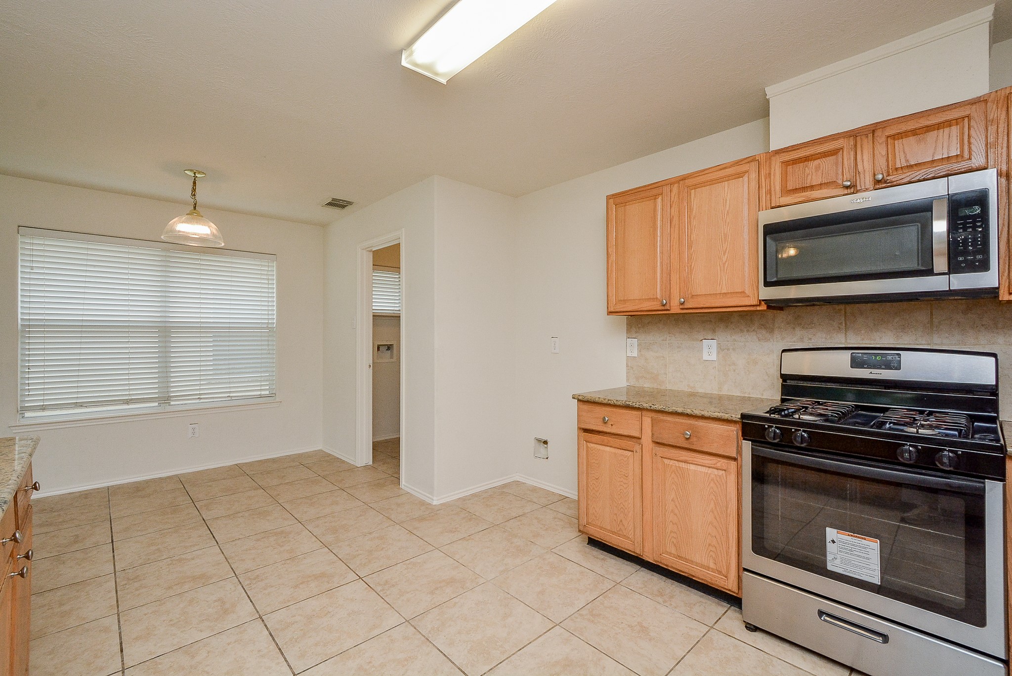 18326 Thicket Grove Road Houston, TX 77084 - Photo 19 of 50 a kitchen with stainless steel appliances granite countertop a stove top oven a sink a counter space and cabinets