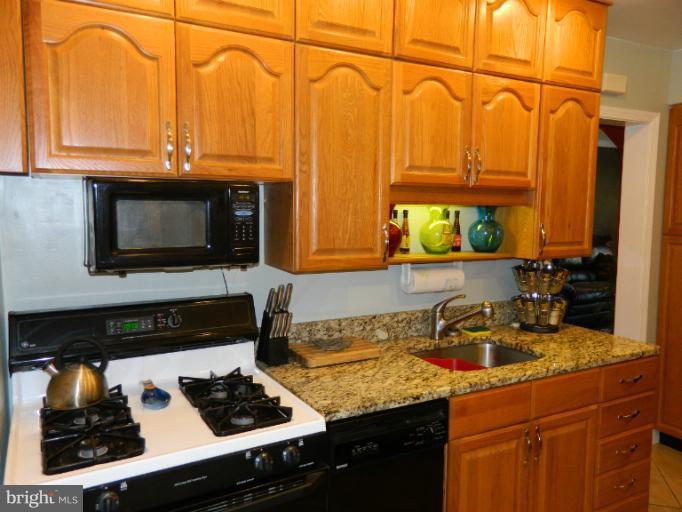 67 Garden Ridge Road Baltimore, MD 21228 - Photo 11 of 26 a kitchen with stainless steel appliances granite countertop a sink stove and cabinets