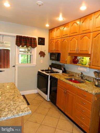 67 Garden Ridge Road Baltimore, MD 21228 - Photo 15 of 26 a kitchen with stainless steel appliances granite countertop a stove and a sink