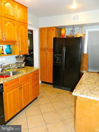 67 Garden Ridge Road Baltimore, MD 21228 - Photo 8 of 26 a kitchen with stainless steel appliances granite countertop a refrigerator and a sink