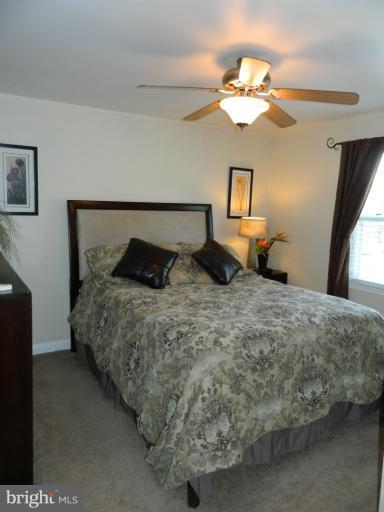 67 Garden Ridge Road Baltimore, MD 21228 - Photo 9 of 26 a bedroom with a bed and a chandelier