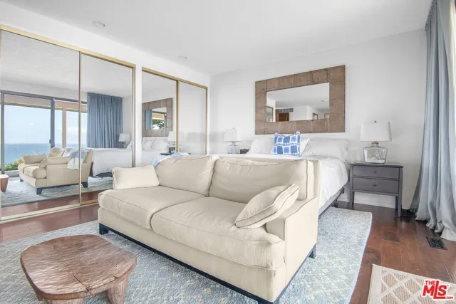 a living room with a bed furniture and a potted plant