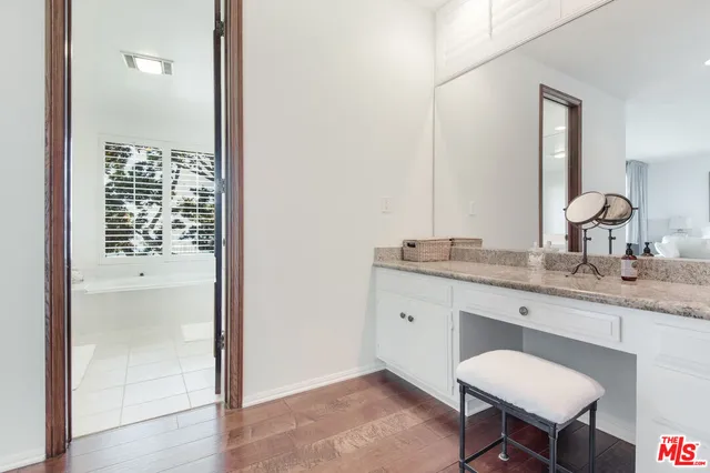 a bathroom with a granite countertop sink a toilet and a mirror