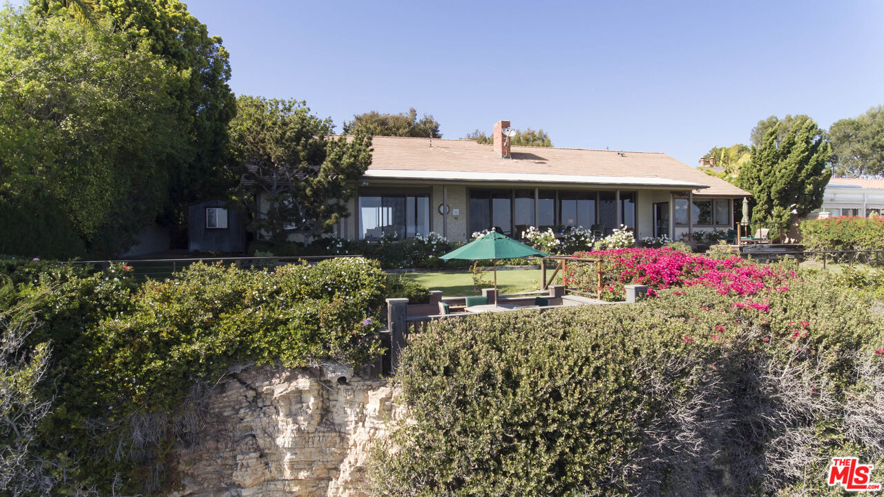 29008 Cliffside Drive Malibu, CA 90265 - Photo 2 of 28 a view of a patio with table and chairs under an umbrella
