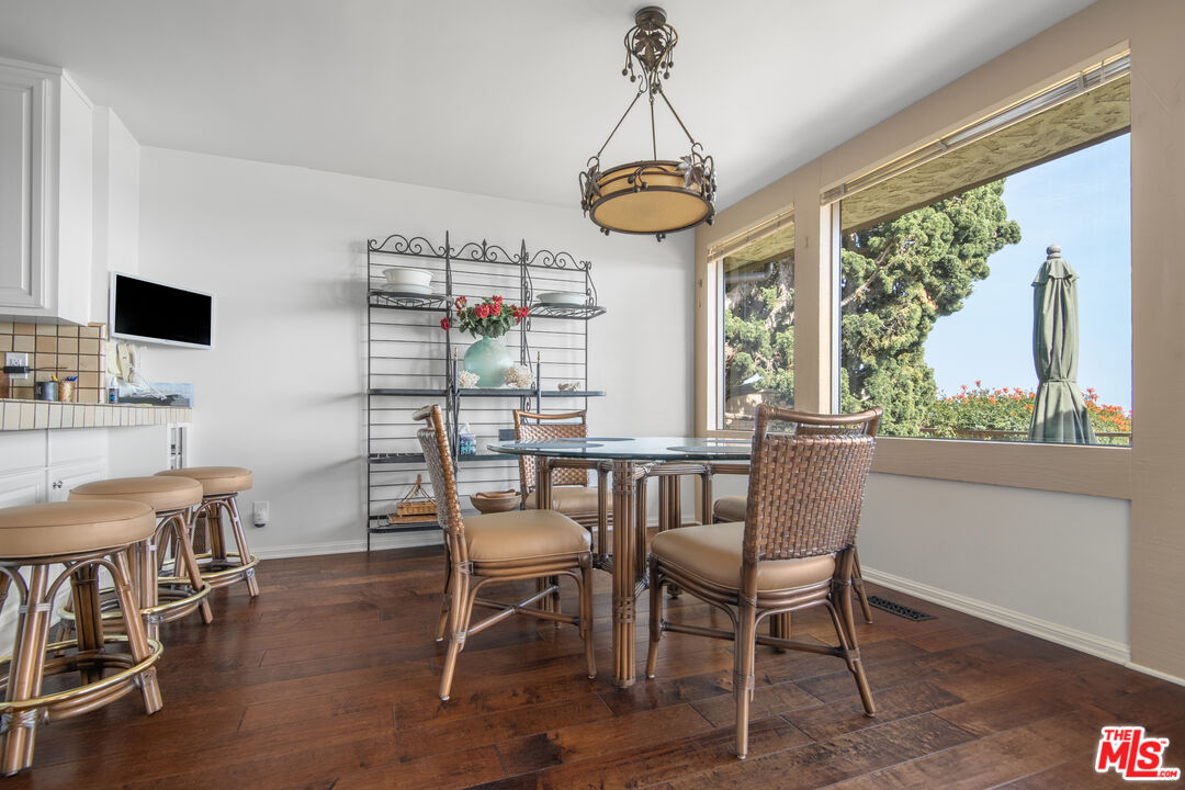 29008 Cliffside Drive Malibu, CA 90265 - Photo 10 of 28 a dining room with furniture a chandelier and wooden floor