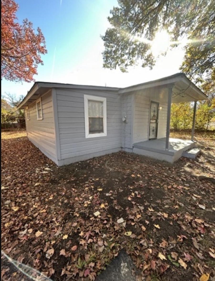 Light gray siding exterior with white trim windows and a covered front porch featuring two support columns