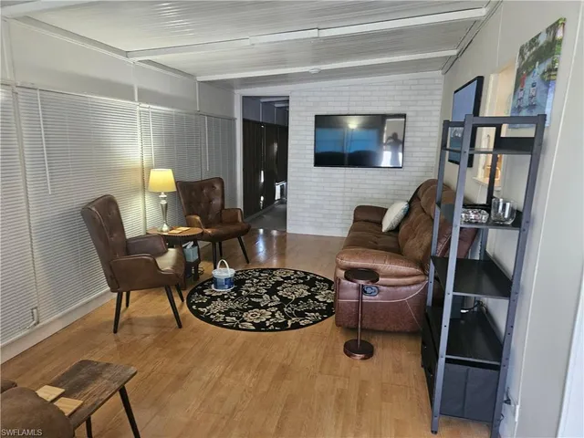 a living room with furniture a flat screen tv and a table