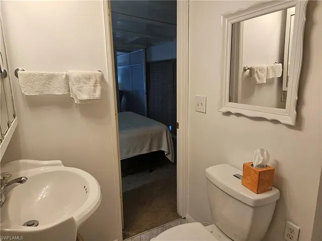 a bathroom with a sink and mirror with toilet