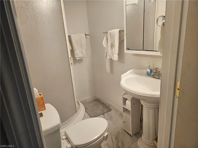 a bathroom with a sink a toilet and shower curtain