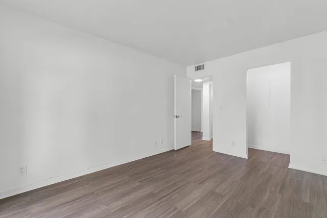 a view of an empty room with wooden floor