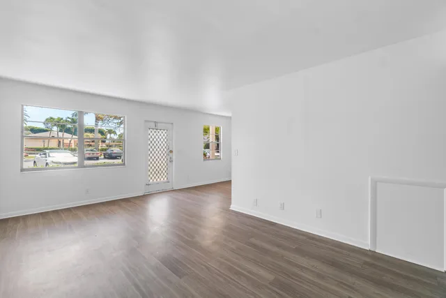 an empty room with wooden floor and window