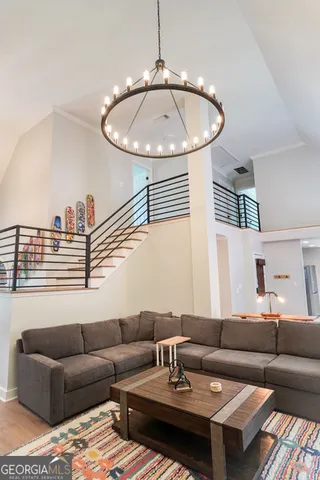 a living room with furniture a dining table and a chandelier