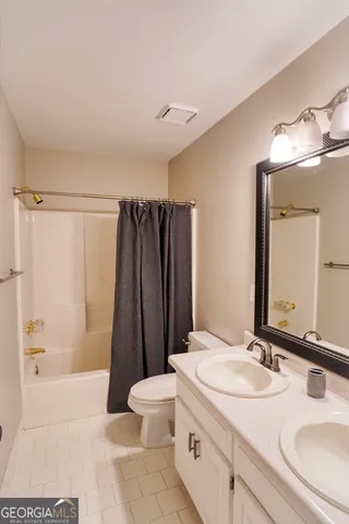 a bathroom with a sink a toilet a mirror and shower