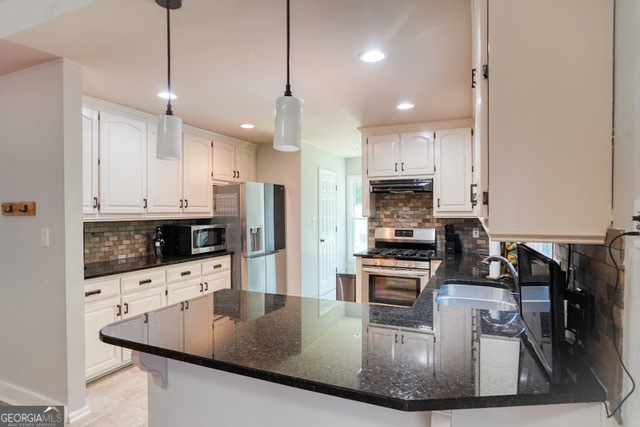 335 Butterfield Lane Fayetteville, GA 30214 - Photo 7 of 27 a kitchen with stainless steel appliances granite countertop a sink a stove and a refrigerator