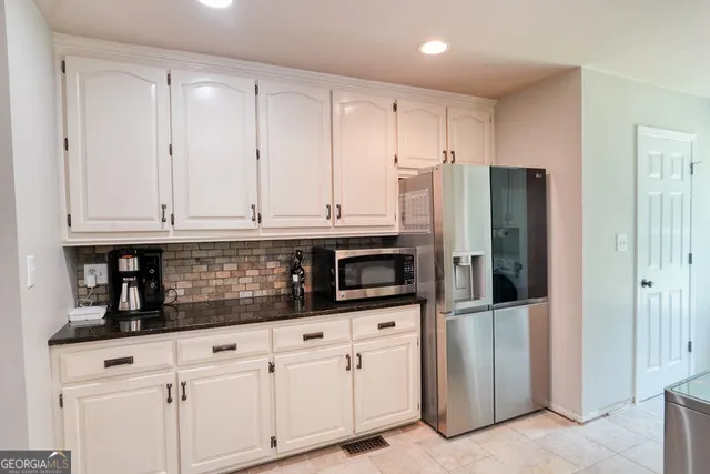 a kitchen with stainless steel appliances white cabinets and refrigerator