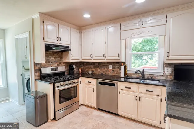 a kitchen with white cabinets and white appliances