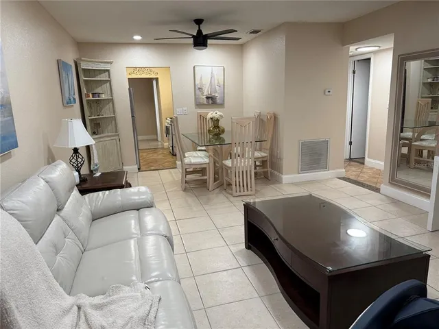 a living room with furniture a flat screen tv and a dining table