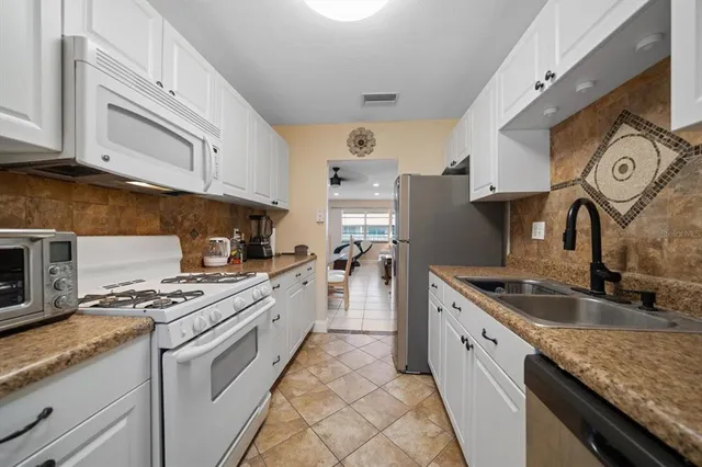 a kitchen with granite countertop a sink stainless steel appliances and cabinets