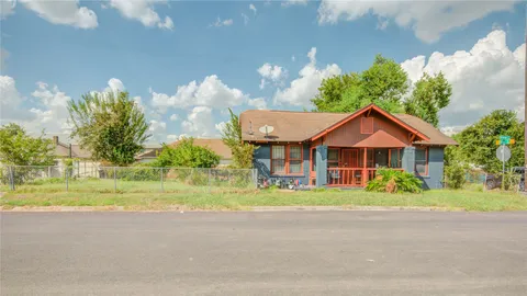 a front view of a house with a yard and potted plants