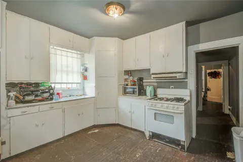 a kitchen with a stove a sink and cabinets