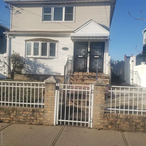 a view of a house with a door and wooden fence