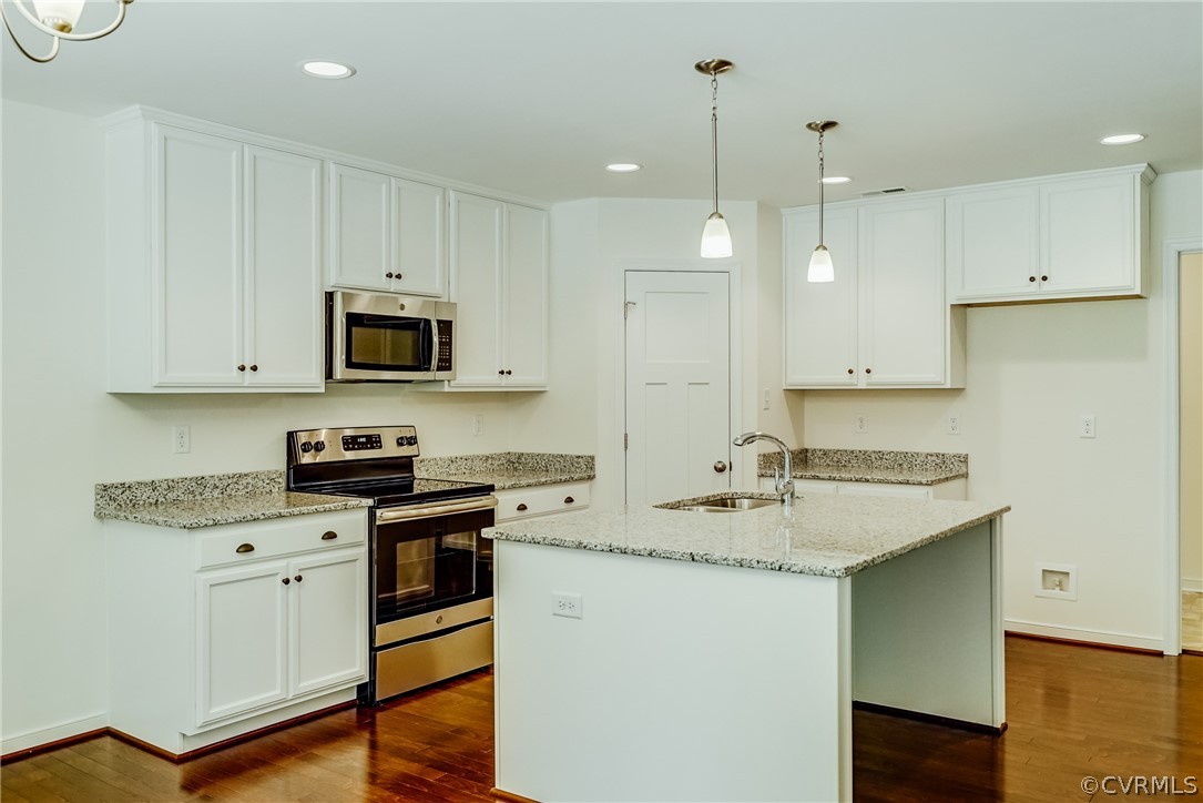 a kitchen with a sink a stove a refrigerator and white cabinets