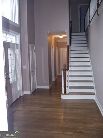 a view of a hallway with wooden floor and staircase