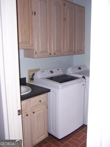 a utility room with sink dryer and washer