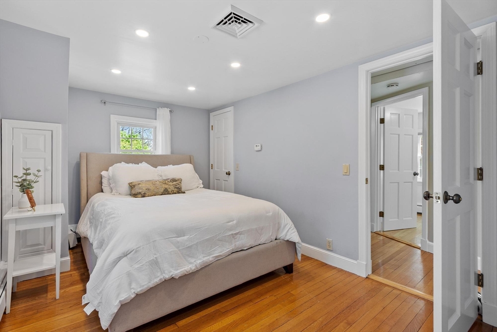 25 Naples Road Melrose, MA 02176 - Photo 16 of 36 a spacious bedroom with a bed and a wooden floor