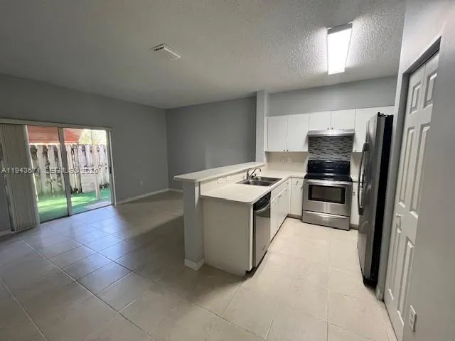a kitchen with a refrigerator sink and stove