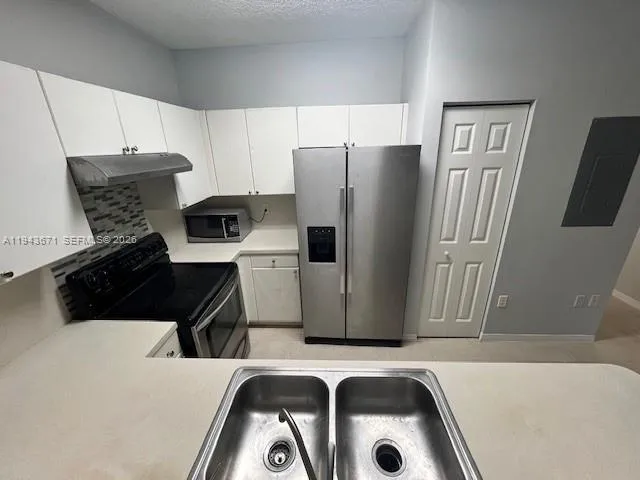a kitchen with a refrigerator and a sink
