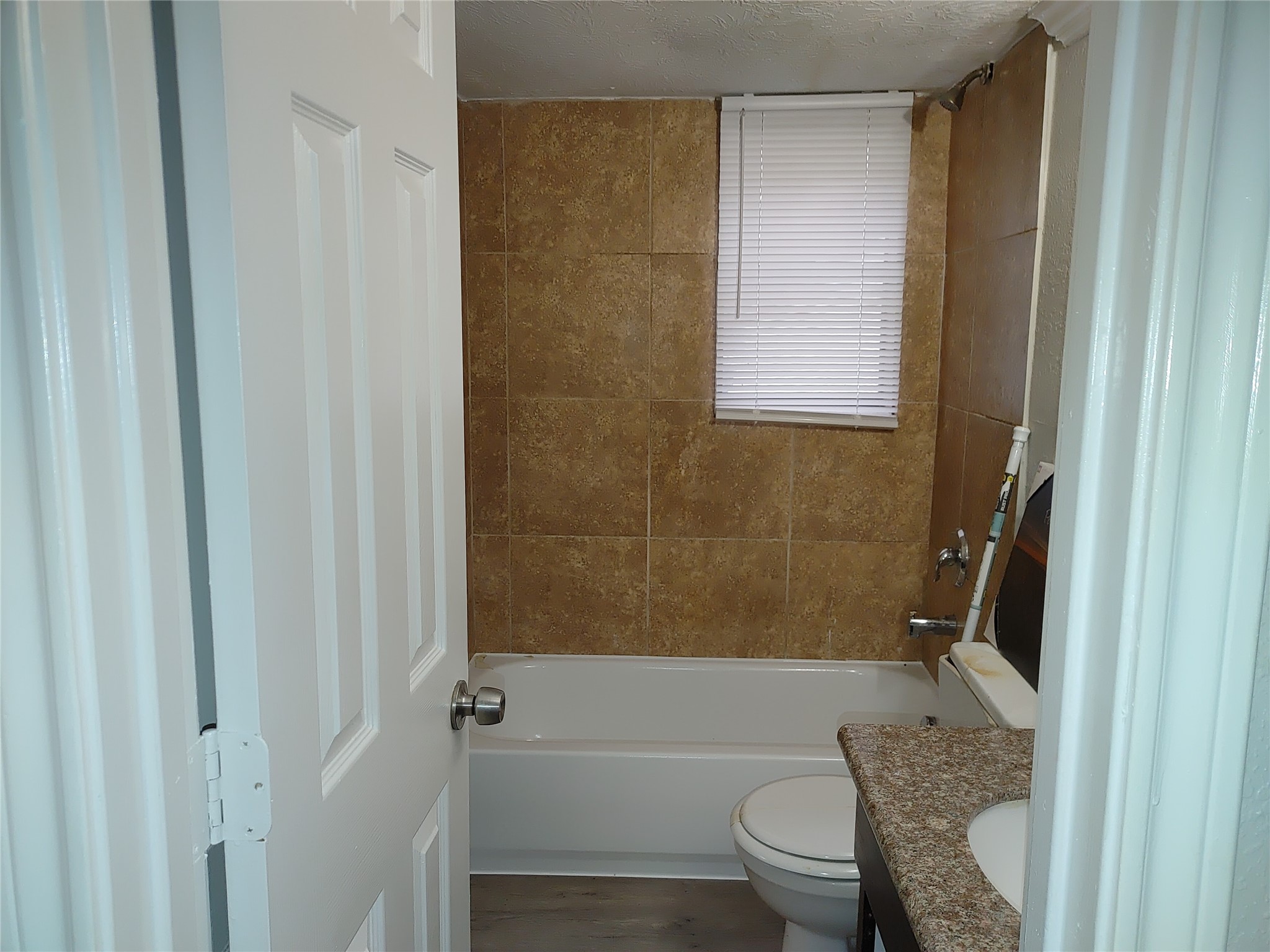 6204 Culberson Street, Unit 12 Houston, TX 77021 - Photo 4 of 6 a bathroom with a granite countertop bathtub shower sink vanity and toilet