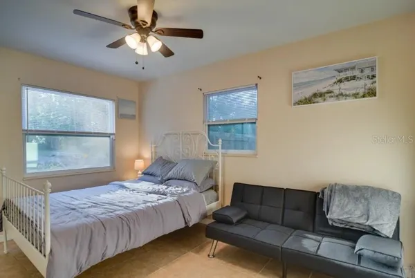 a bedroom with a bed couch and window