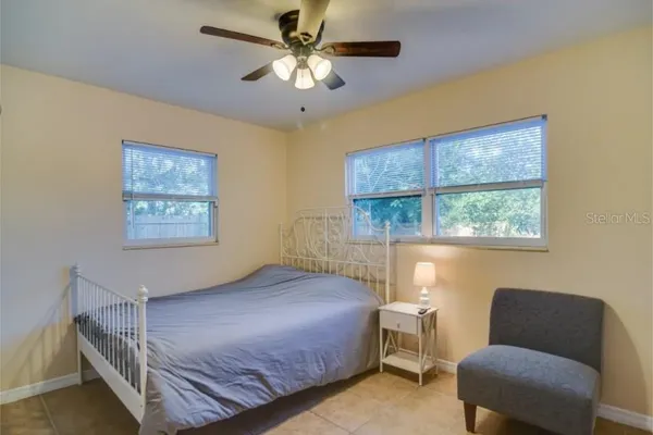 a bedroom with a bed window and chair