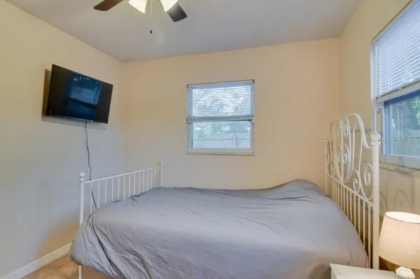 a view of a bedroom with wooden floor and windows