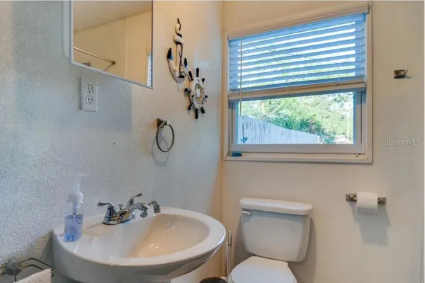 a bathroom with a toilet a sink and a window