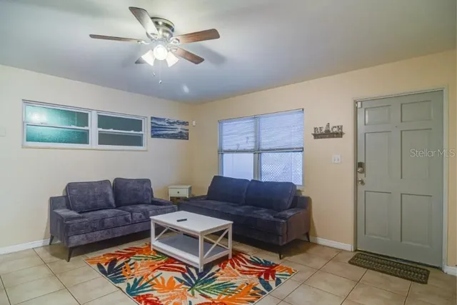 a living room with furniture a ceiling fan and a rug