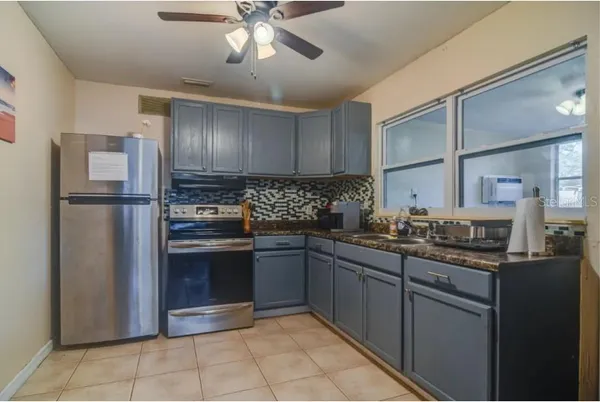 a kitchen with stainless steel appliances granite countertop a refrigerator and a sink