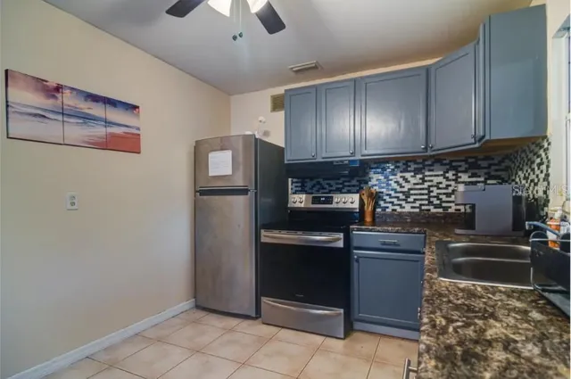 a kitchen with stainless steel appliances granite countertop a refrigerator and a stove