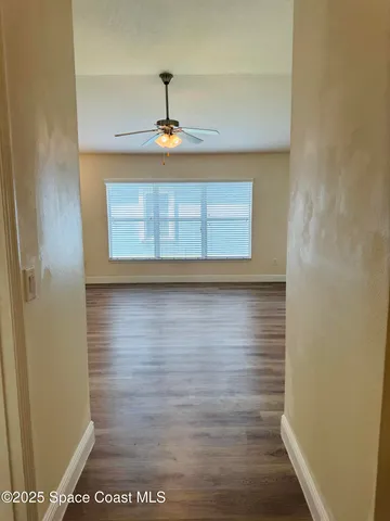 a view of a hallway with wooden floor