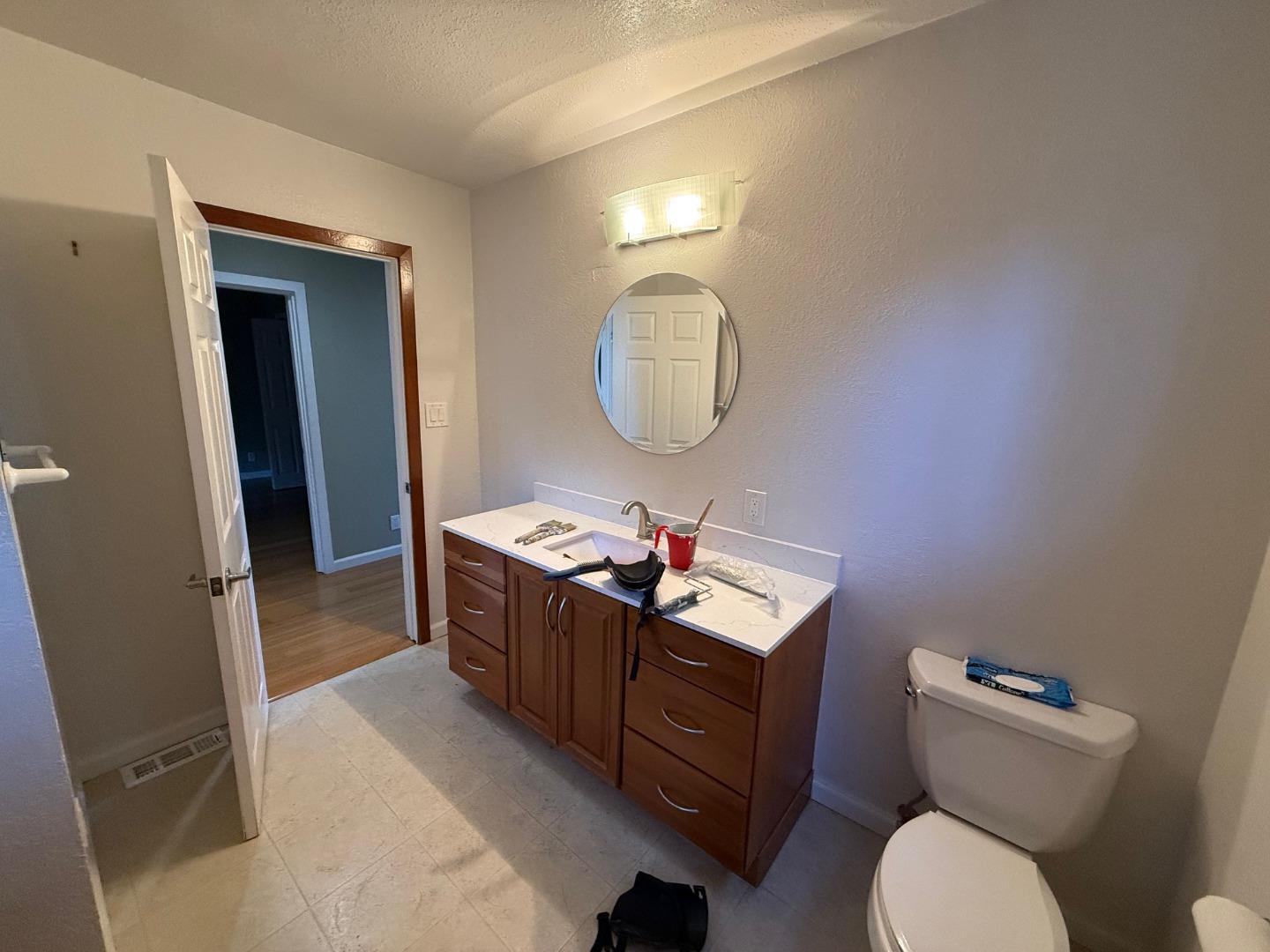 252 Swett Road Woodside, CA 94062 - Photo 9 of 21 a bathroom with a toilet a sink a mirror and vanity