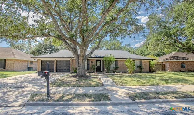 a front view of a house with yard patio and green space