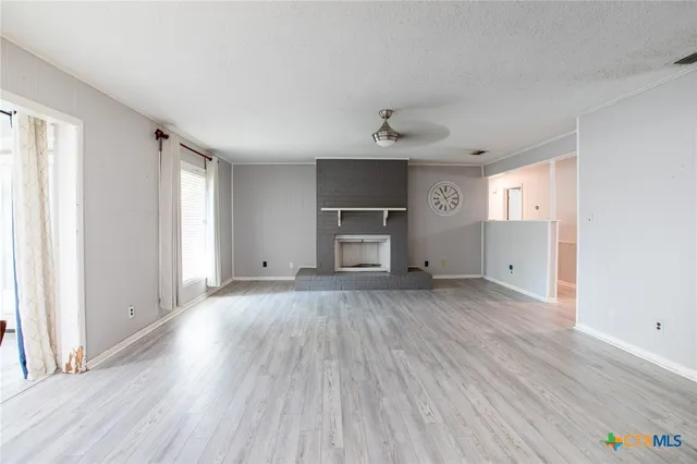 a view of empty room with wooden floor and window