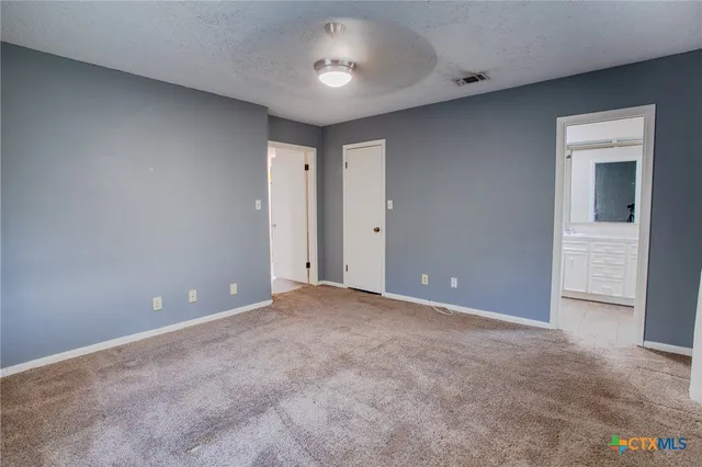 a view of an empty room with a ceiling fan