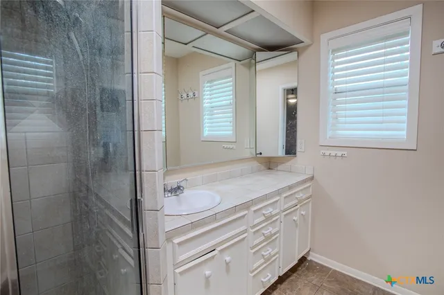 a bathroom with a granite countertop sink a vanity and a mirror